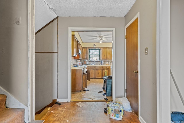 corridor featuring sink, a textured ceiling, and light parquet floors