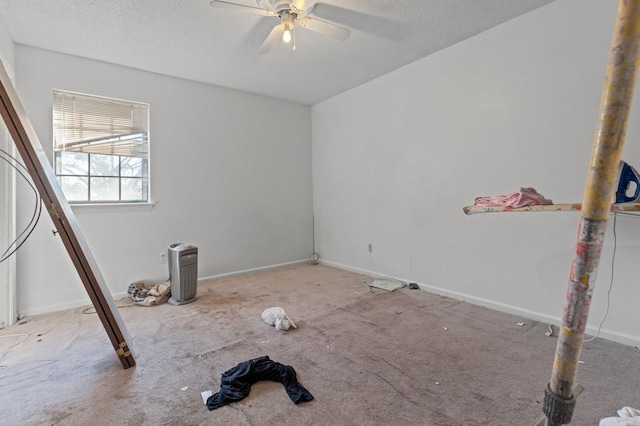 empty room with a textured ceiling, carpet flooring, and ceiling fan