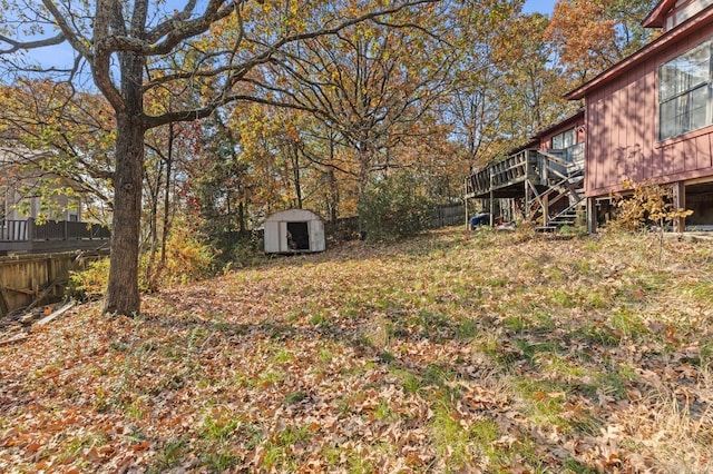 view of yard featuring a wooden deck and a shed