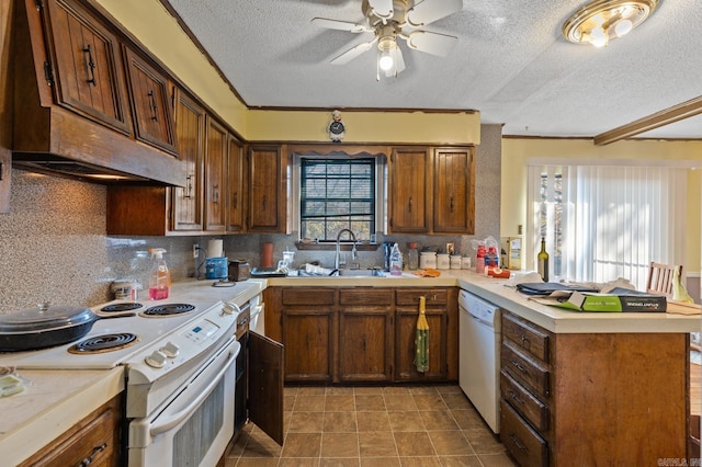 kitchen featuring kitchen peninsula, sink, a textured ceiling, white appliances, and ceiling fan