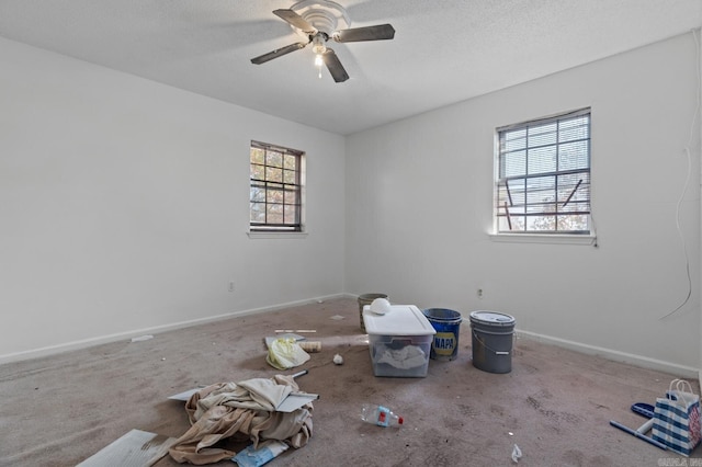 carpeted spare room featuring a textured ceiling and ceiling fan