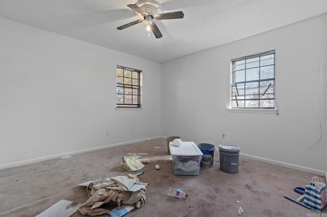 empty room featuring a textured ceiling, carpet flooring, and ceiling fan