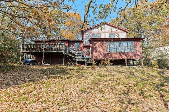 rear view of house featuring a deck and a lawn