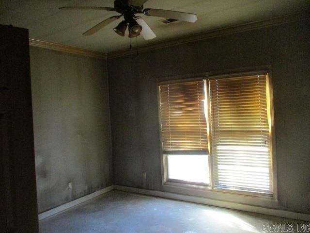 spare room featuring ornamental molding, concrete flooring, and ceiling fan