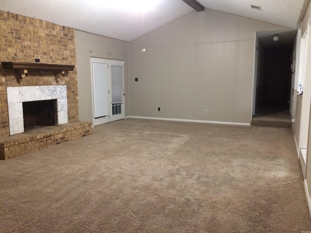 unfurnished living room featuring vaulted ceiling with beams, carpet floors, and a textured ceiling