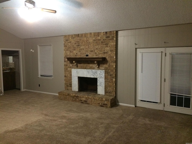 unfurnished living room with lofted ceiling, carpet, a textured ceiling, and a large fireplace