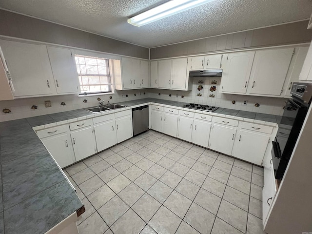 kitchen featuring stainless steel appliances, backsplash, sink, white cabinets, and a textured ceiling