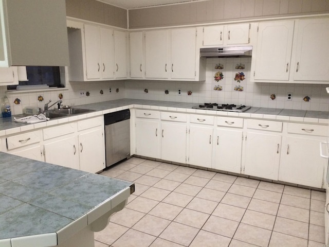 kitchen with sink, dishwasher, tile counters, and white cabinets