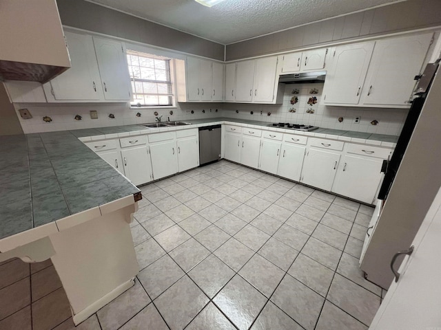 kitchen with sink, appliances with stainless steel finishes, kitchen peninsula, and white cabinets