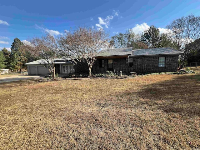 single story home featuring a front lawn and a garage