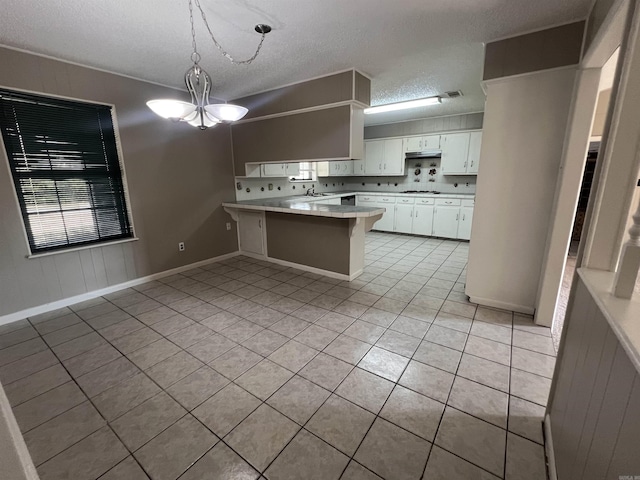 8096 Zuber Rd, Benton, AR 72019 - kitchen featuring a peninsula, light tile patterned floors, a textured ceiling, white cabinetry, and light countertops