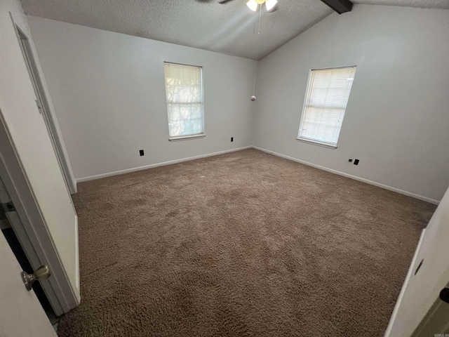 spare room featuring dark colored carpet, vaulted ceiling with beams, a textured ceiling, and ceiling fan