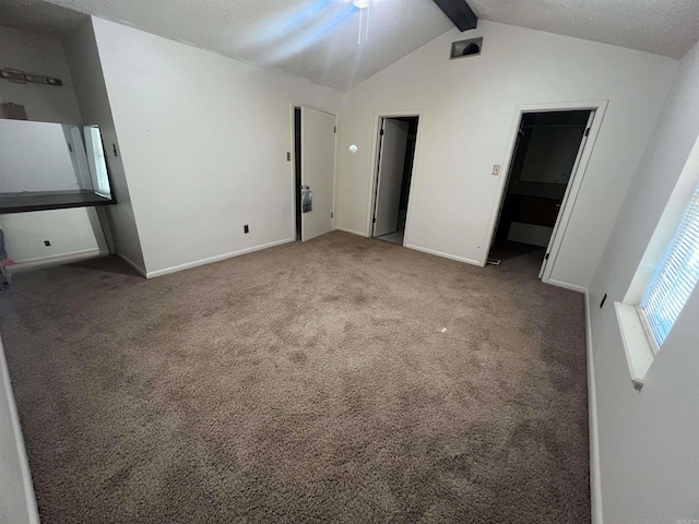 unfurnished bedroom featuring vaulted ceiling with beams, carpet, and ceiling fan