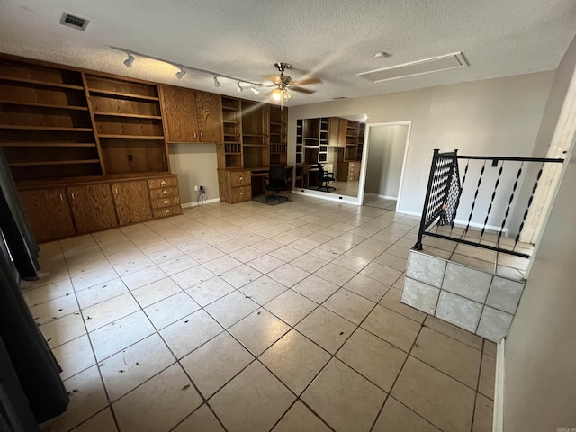 8096 Zuber Rd, Benton, AR 72019 - unfurnished living room with ceiling fan, a textured ceiling, attic access, light tile patterned floors, and built in shelves