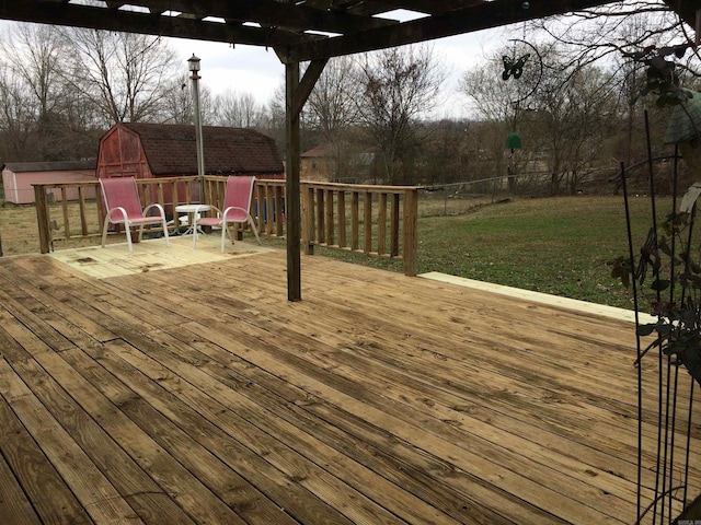 wooden deck featuring a storage unit and a lawn