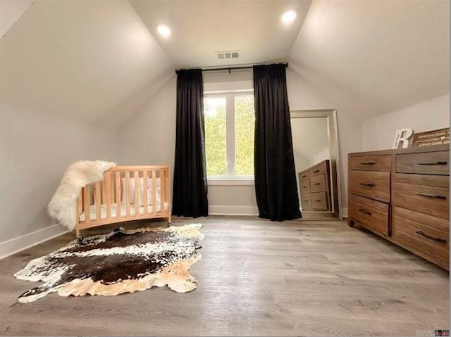 bedroom with lofted ceiling and light hardwood / wood-style flooring