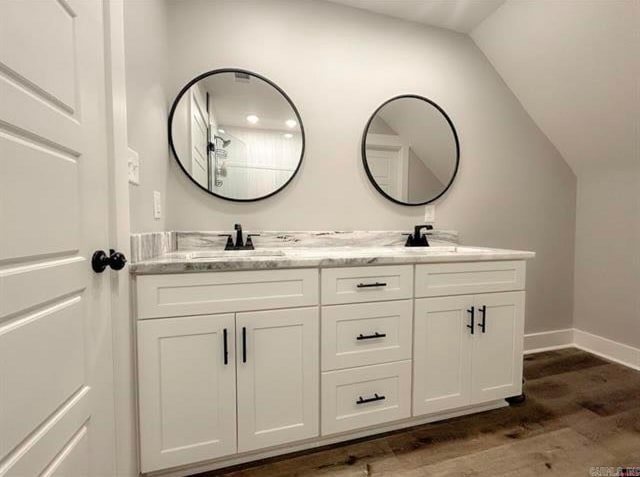 bathroom featuring vanity, hardwood / wood-style floors, and vaulted ceiling