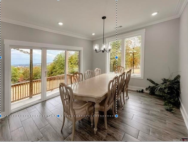 dining space with crown molding, a healthy amount of sunlight, wood-type flooring, and a chandelier