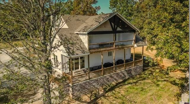 rear view of property featuring a sunroom and a balcony