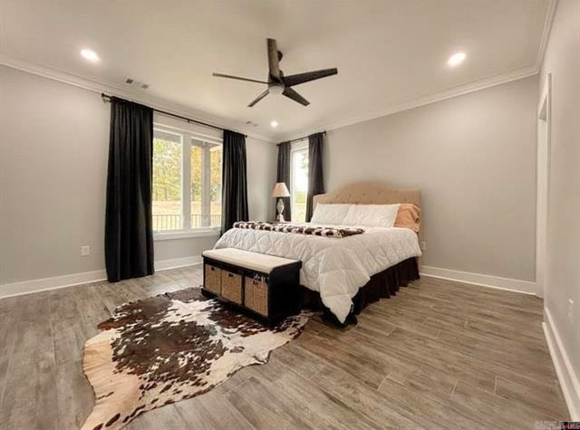 bedroom featuring ornamental molding, wood-type flooring, and ceiling fan