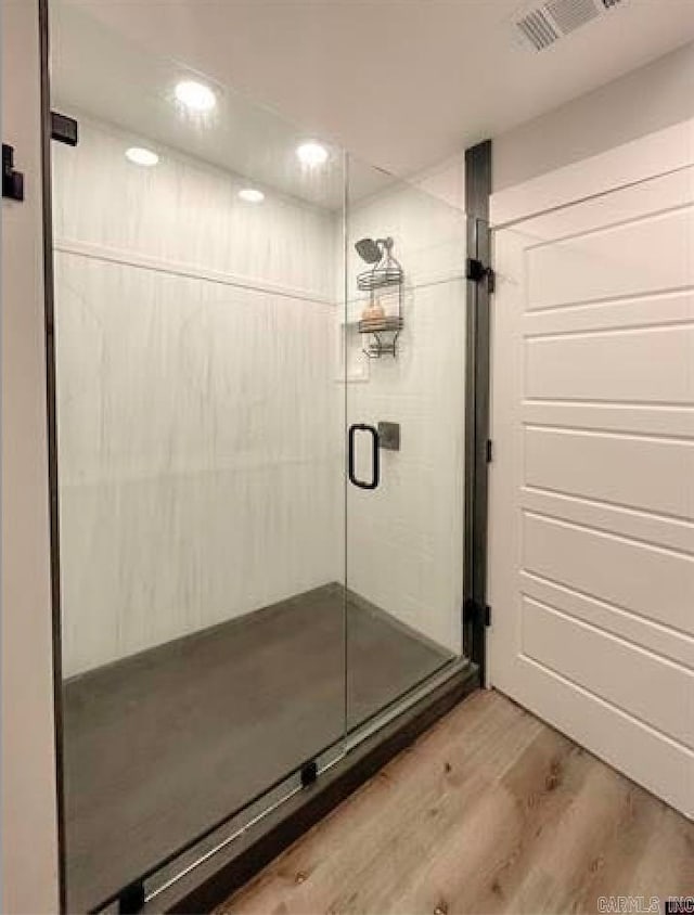 bathroom featuring hardwood / wood-style floors and a shower with shower door