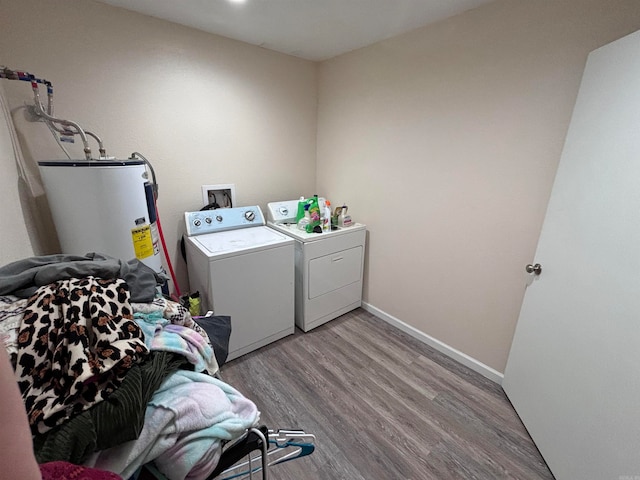 laundry area featuring electric water heater, light hardwood / wood-style flooring, and independent washer and dryer