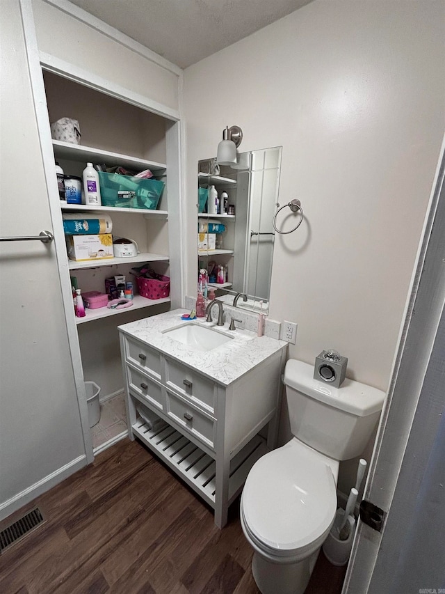 bathroom featuring vanity, hardwood / wood-style floors, and toilet