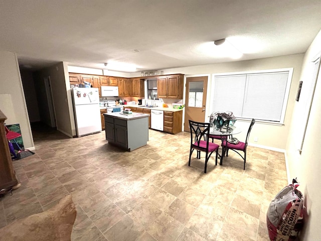 kitchen with white appliances, sink, and a kitchen island