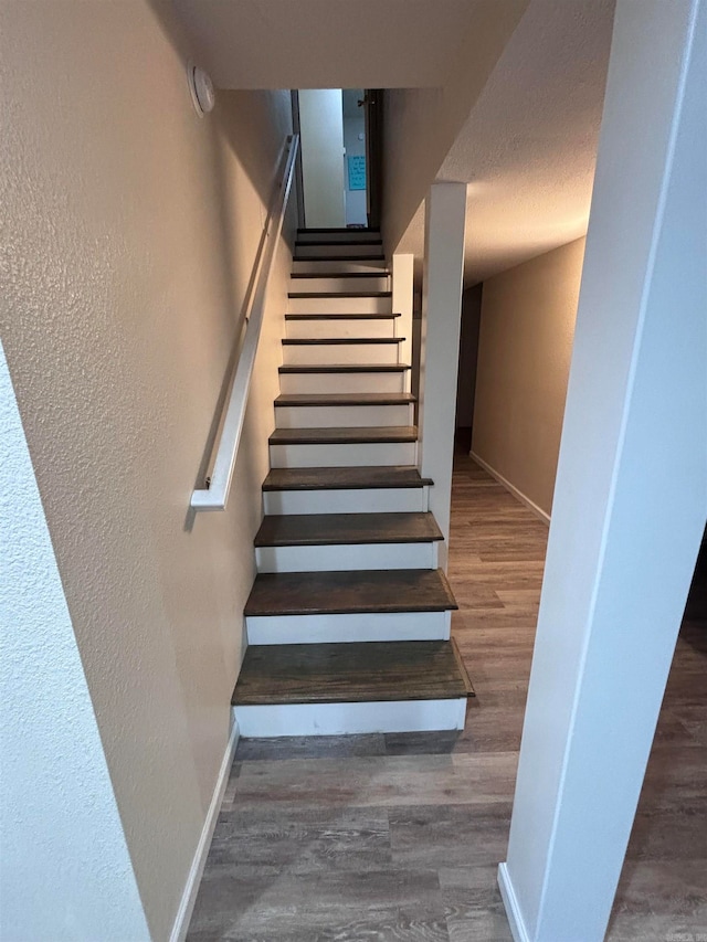 stairway featuring wood-type flooring