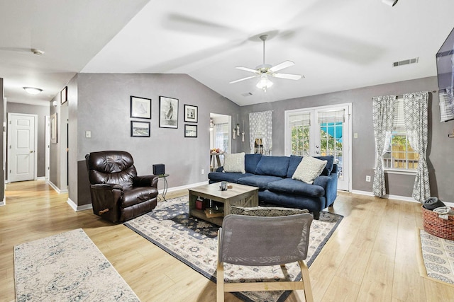 living room with light hardwood / wood-style flooring, french doors, ceiling fan, and vaulted ceiling