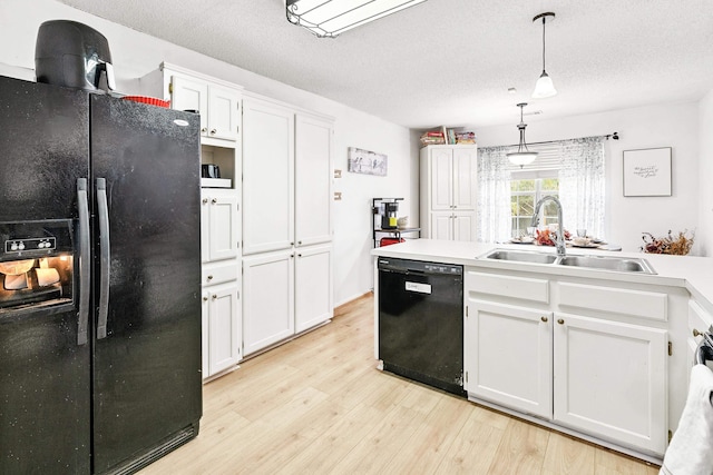 kitchen with white cabinetry, black appliances, hanging light fixtures, and sink