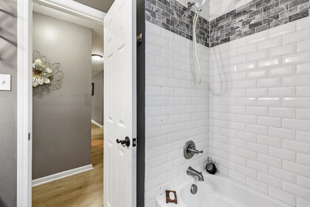 bathroom featuring hardwood / wood-style flooring and tiled shower / bath