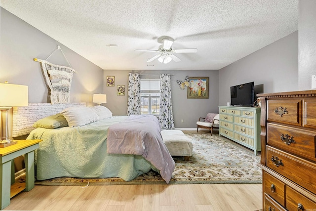 bedroom featuring ceiling fan, a textured ceiling, and light hardwood / wood-style flooring