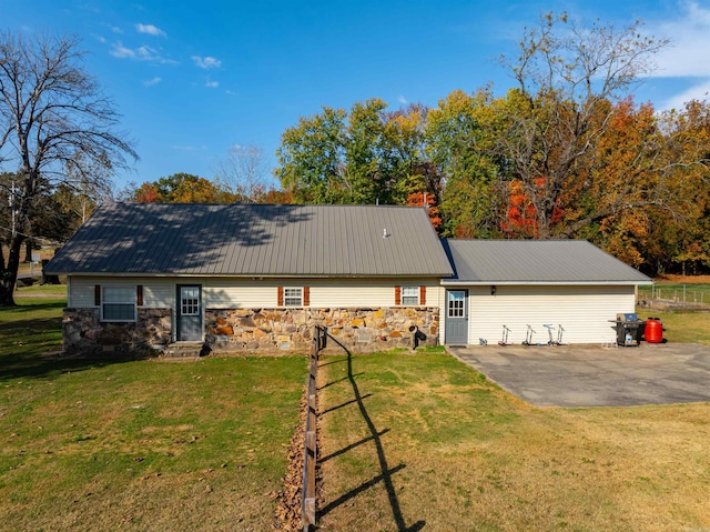 ranch-style house featuring a front lawn and a patio area