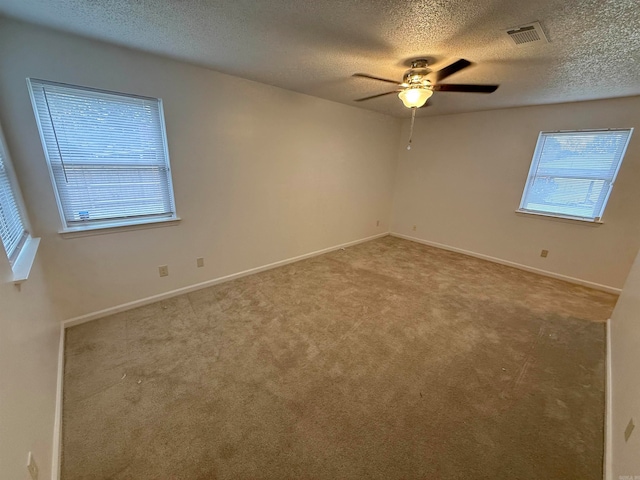 empty room featuring ceiling fan, a textured ceiling, and carpet floors