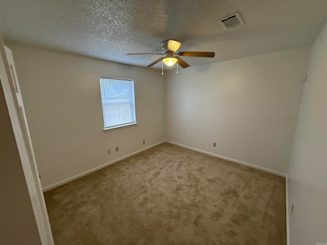 unfurnished room featuring ceiling fan, carpet, and a textured ceiling