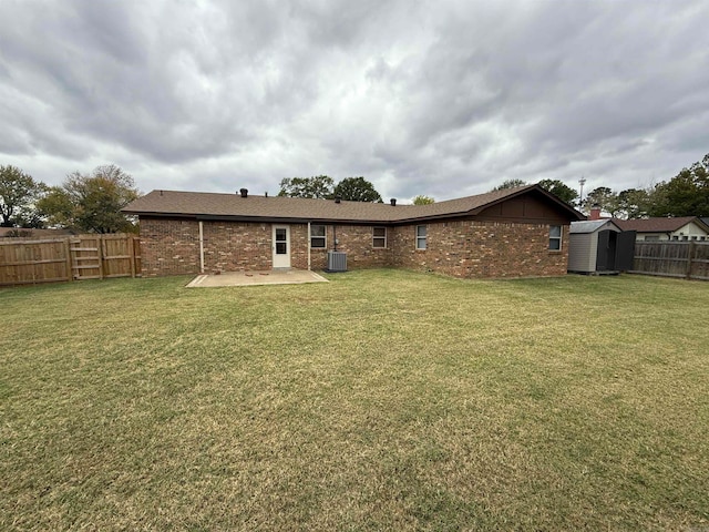 rear view of house with a yard, a patio area, a shed, and central AC unit