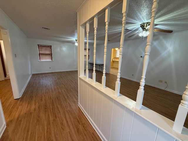 hallway with a textured ceiling and hardwood / wood-style flooring