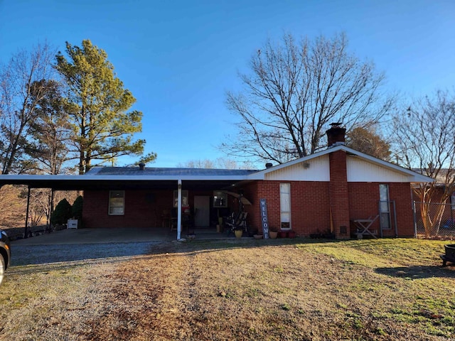 rear view of property featuring a yard and a carport