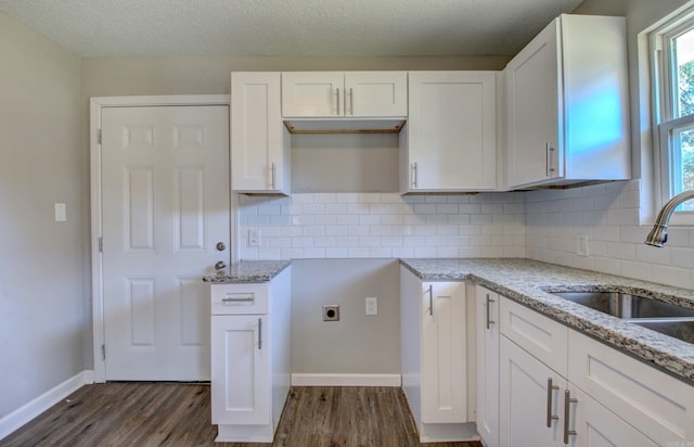 1321 S Pear St, Pine Bluff, AR 71603 - kitchen with light stone counters, a sink, white cabinetry, baseboards, and dark wood-style floors