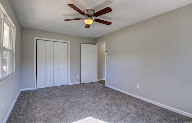 unfurnished bedroom featuring a closet, ceiling fan, carpet, and a textured ceiling