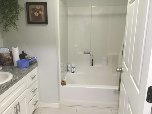 bathroom featuring tile patterned floors, baseboards, vanity, and tub / shower combination