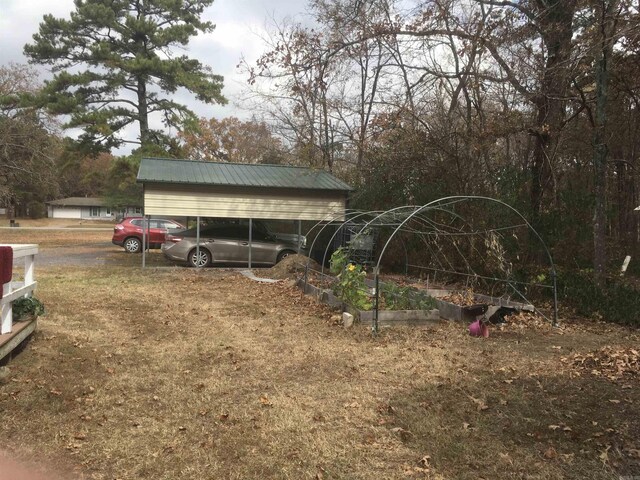 view of yard with a detached carport and a vegetable garden