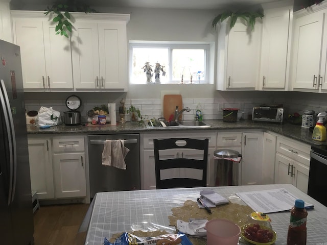 kitchen with sink, white cabinetry, stainless steel appliances, decorative backsplash, and dark hardwood / wood-style floors