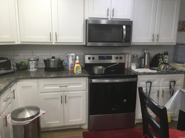kitchen with white cabinets, stainless steel appliances, decorative backsplash, and a toaster