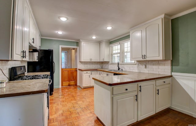 kitchen with kitchen peninsula, white cabinets, sink, light parquet floors, and white gas range oven