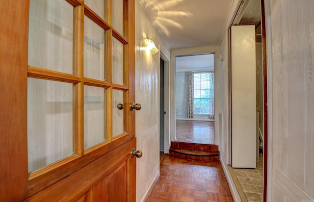 hallway with parquet floors and a textured ceiling