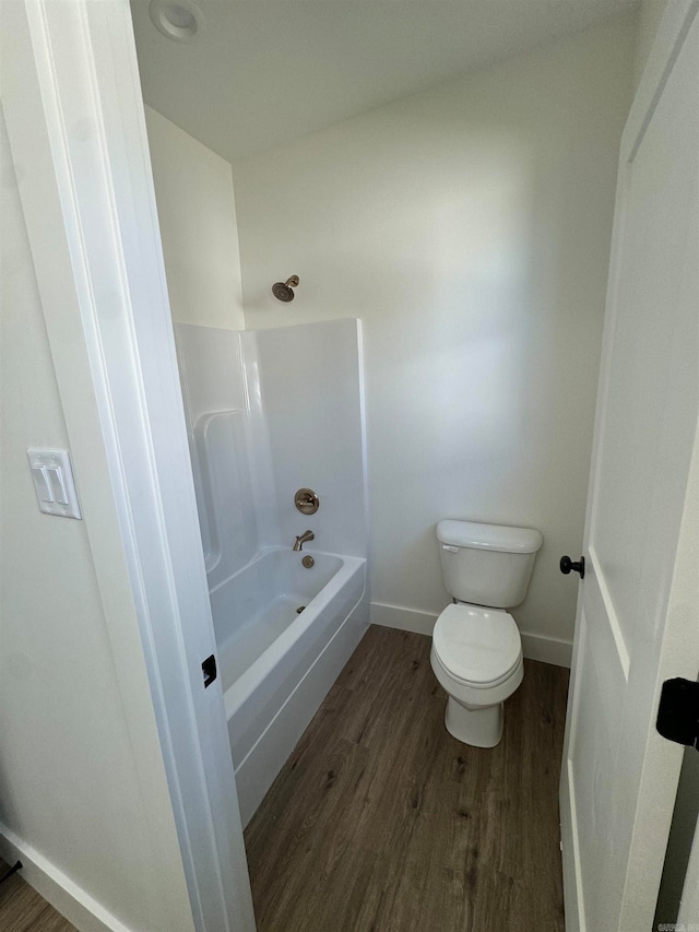 bathroom featuring toilet, shower / bathing tub combination, and wood-type flooring