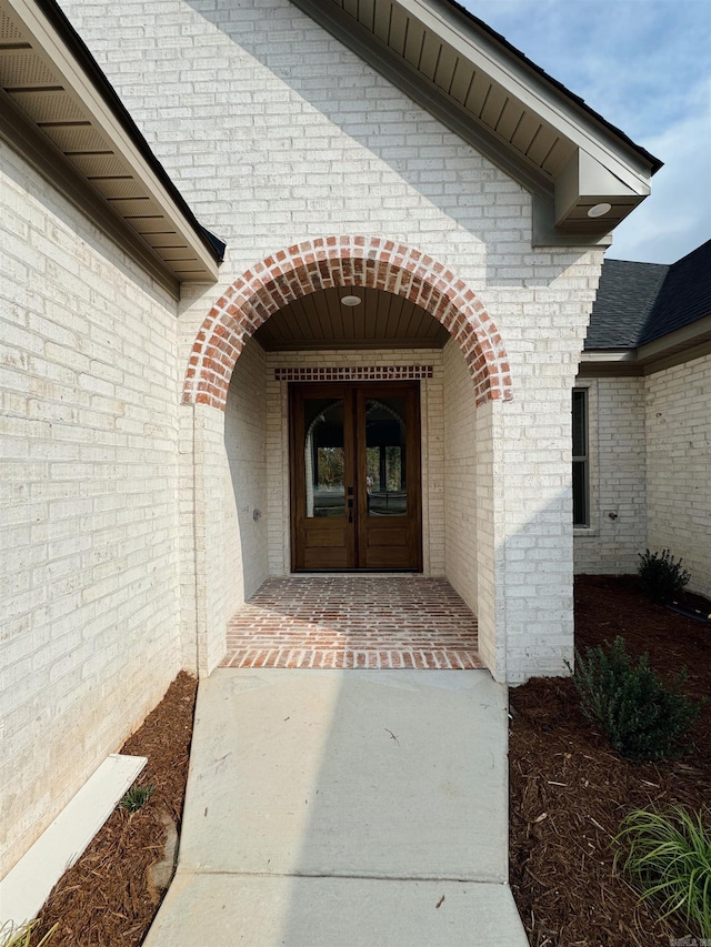 view of exterior entry with a porch and french doors