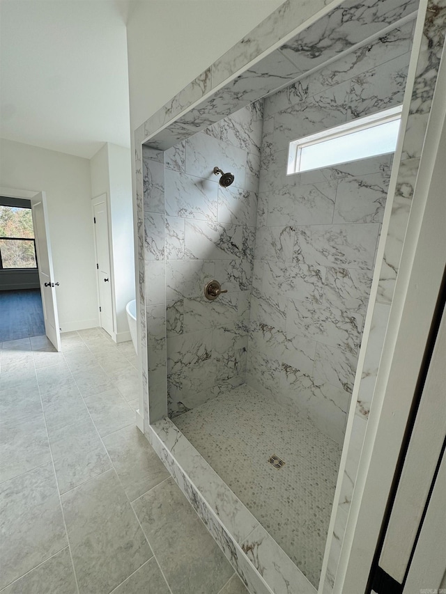 bathroom featuring tile patterned flooring and tiled shower